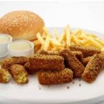 Albaik falafel meal with golden falafel, tahini sauce, pita bread, and fries.